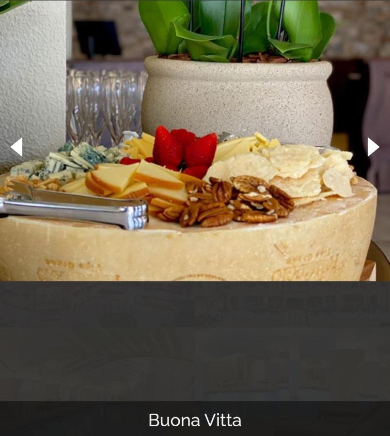 Buona Vitta Gramado Resort & Spa By Gramado Parks Exteriör bild The photo displays a beautiful cheese platter. It features a large round cheese wheel as the base, surrounded by various types of cheeses including soft and hard varieties. There are also some crackers or crisps, along with nuts, particularly pecans.