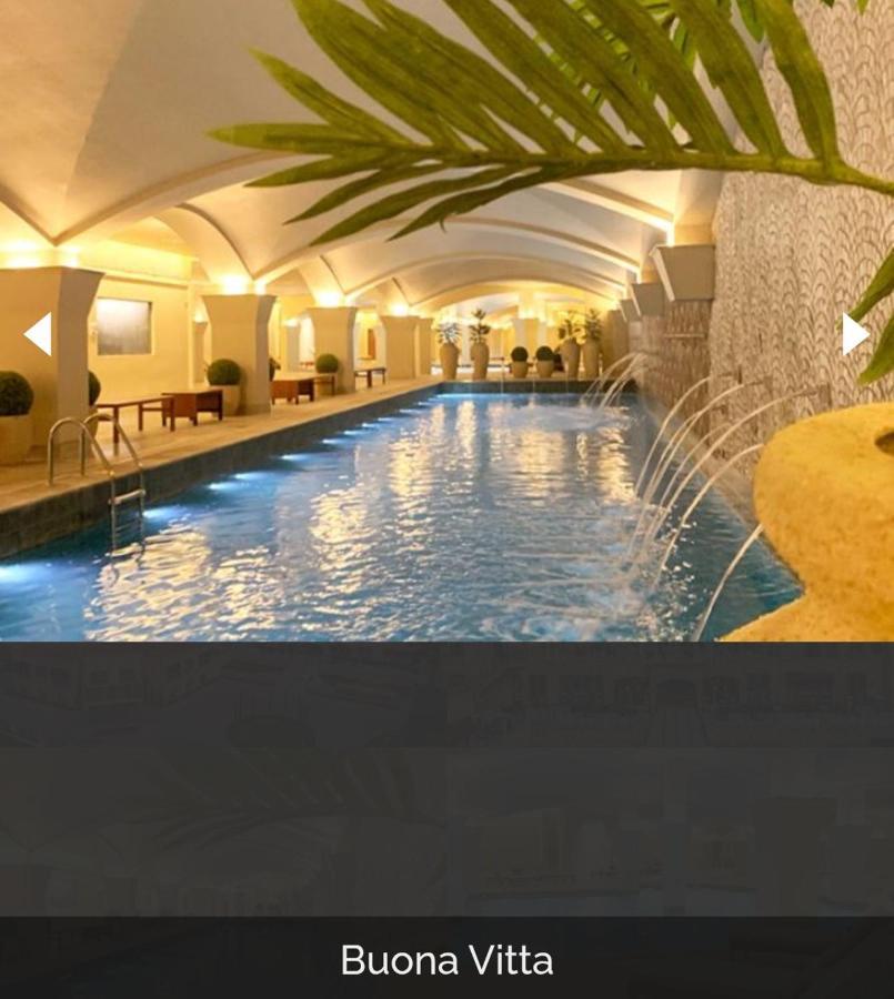 Buona Vitta Gramado Resort & Spa By Gramado Parks Exteriör bild The photo depicts an elegant indoor swimming pool area. The pool is illuminated with lights along its edge, and there are gentle water features creating a calming atmosphere. The ceiling has an arched design, and the space is decorated with plants an