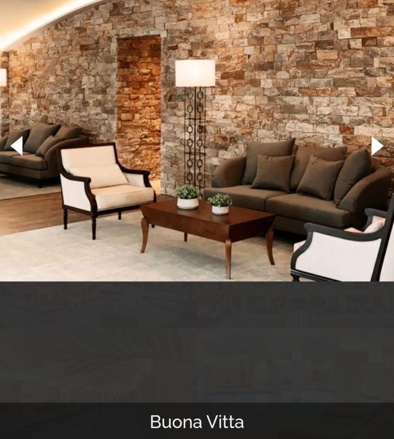 Buona Vitta Gramado Resort & Spa By Gramado Parks Exteriör bild The image shows a stylish living room setting. There are two sofas: one is a dark brown color, and the other is a cream color with dark wooden accents. In the center, there is a wooden coffee table with a smooth finish and decorative plants on top. T