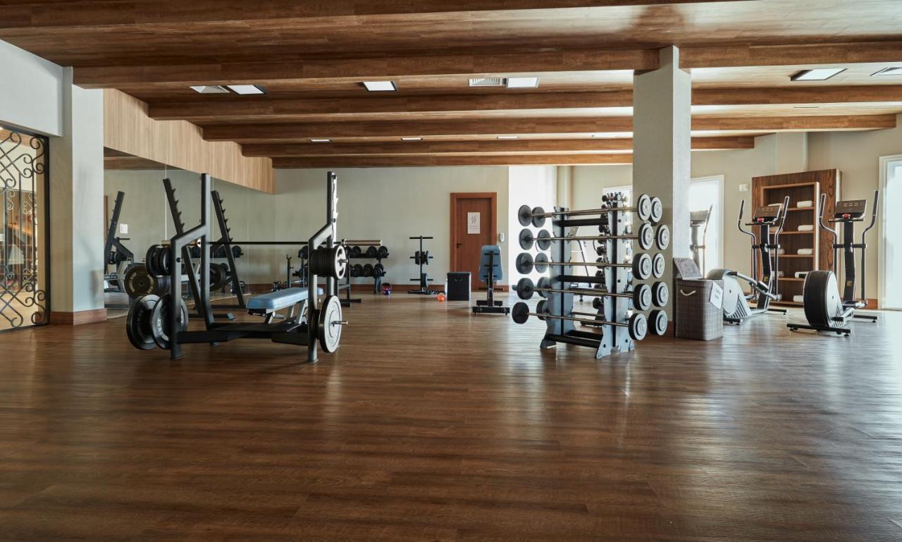 Buona Vitta Gramado Resort & Spa By Gramado Parks Exteriör bild The photo shows a spacious gym with a wooden floor and wooden ceiling beams. Various pieces of gym equipment are visible, including weight benches and racks with weights. On one side, there are free weights organized on a rack, while other equipment 