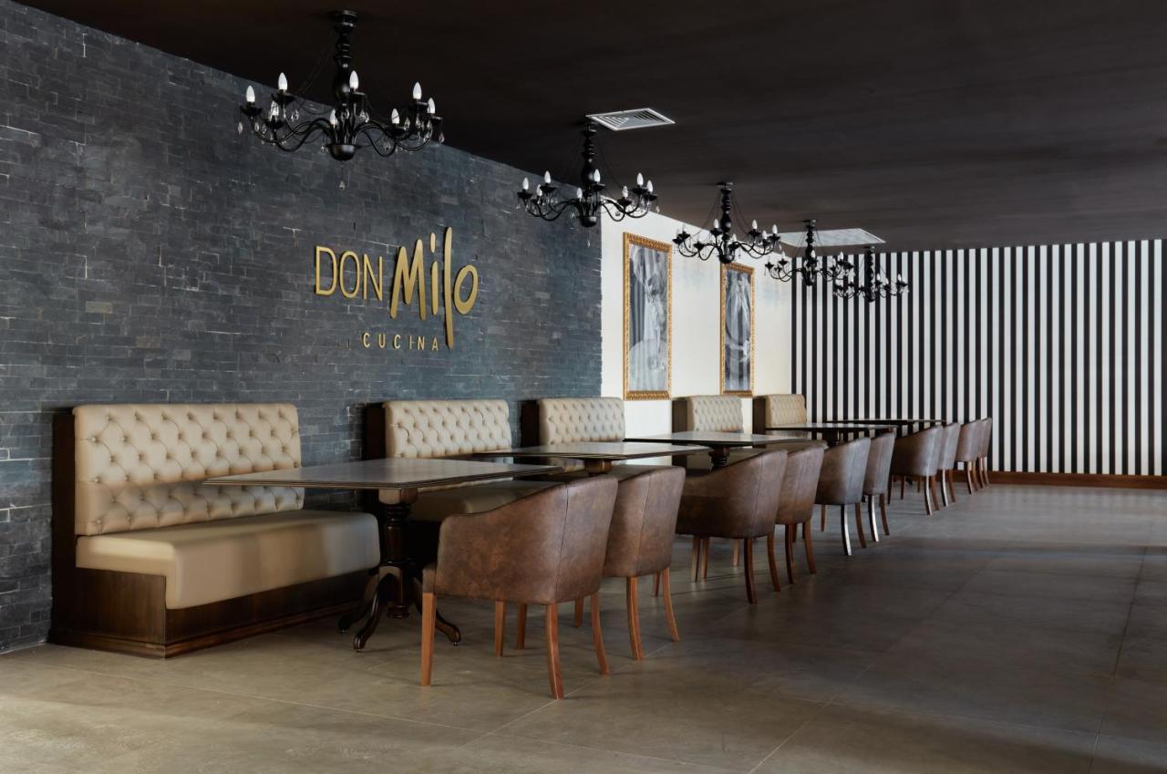 Buona Vitta Gramado Resort & Spa By Gramado Parks Exteriör bild The photo showcases an interior of a restaurant named "Don Milo." The design features a modern and sophisticated look with a mix of textures and colors. 

On one side, there are upholstered booths in a neutral tone, creating a comfortable dining area